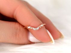 a woman's hand with a diamond ring on her finger and white furnishing