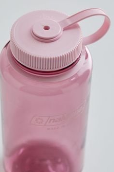 a pink water bottle sitting on top of a white table