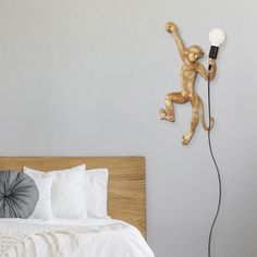 a monkey lamp on the wall next to a bed