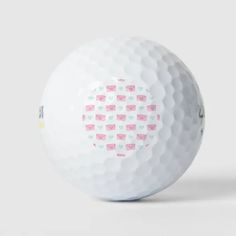 a white golf ball with pink hearts on it