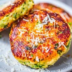 two fritters on a white plate with parmesan cheese