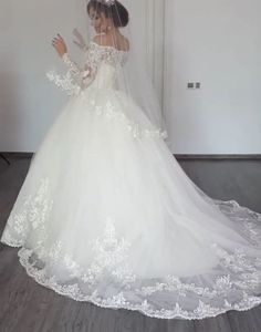 a woman in a white wedding dress is standing on the floor with her hands out