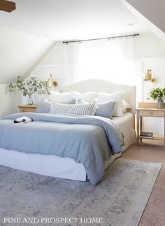 a bedroom with white walls and blue bedding in the corner, along with a rug on the floor