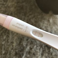 a close up of a toothbrush on a counter with the words pregnant not pregnant written on it