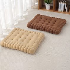 two brown and tan cushions sitting on the floor