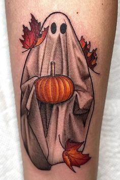 a tattoo with a ghost holding a pumpkin in it's hand and leaves around it