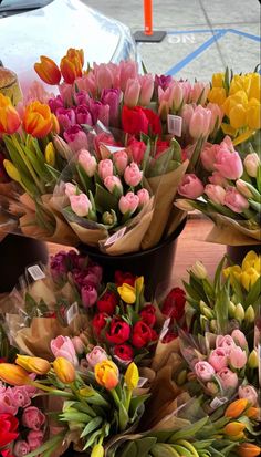 several bouquets of flowers are sitting on the ground next to each other, and one is wrapped in brown paper