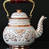 a white and gold tea pot with a wooden handle on it's side, sitting on a black surface