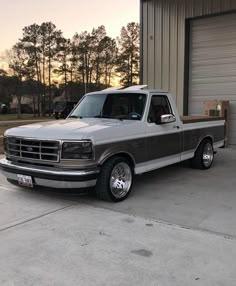 a silver truck parked in front of a garage