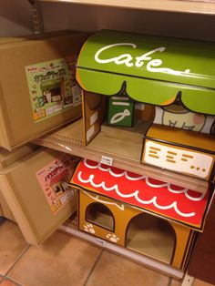 an open cardboard box that is shaped like a store front with the word cafe on it