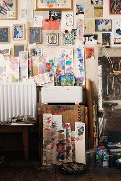 an artist's studio with lots of art on the wall