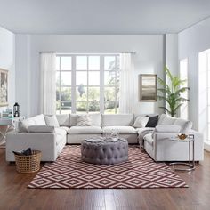 a living room filled with white furniture and lots of windows