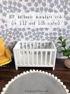 a dollhouse miniature crib in front of a wallpaper