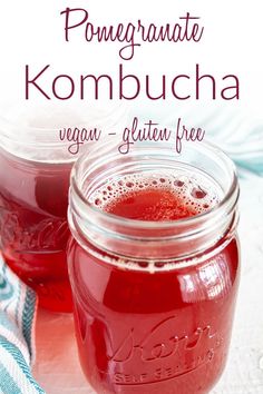 two mason jars filled with kombucha sitting on top of a table