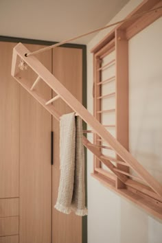 a towel hanging from a clothes rack in a room with wooden closets and cabinets