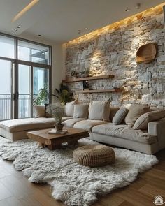 a living room filled with lots of furniture and a stone wall behind the couches