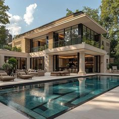 a large house with a swimming pool in front of it and lots of windows on the side