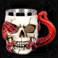 a skull mug with an octopus tentacles on it's side and a red handle