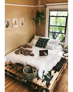 a bed made out of pallets with pillows and blankets on it in a bedroom