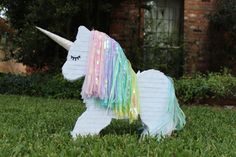 a unicorn made out of paper sitting in the grass