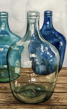 three blue glass bottles sitting on top of a wooden table in front of a white wall