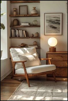 a white chair sitting in front of a wooden shelf filled with books and vases