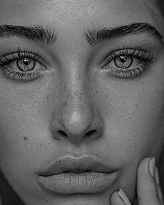 a black and white photo of a woman's face with freckled hair