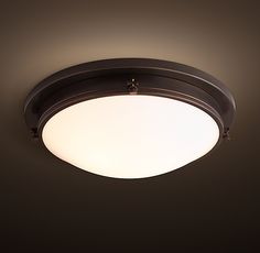 a close up of a ceiling light in a room with dark walls and flooring