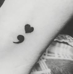 a black and white photo of a person's arm with a heart shaped tattoo on it