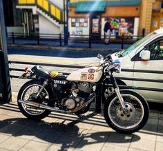 a motorcycle parked next to a white car