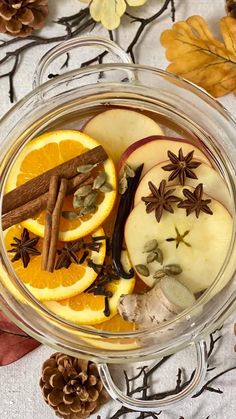 an assortment of fruits and spices in a glass bowl