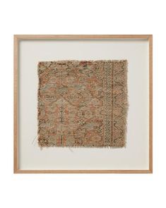 an old rug is hanging in a frame on the wall, with a white background