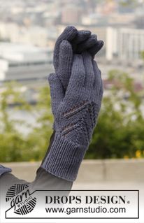 a person with their hand up in the air wearing a pair of gray knitted gloves