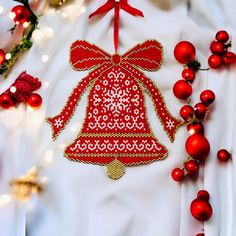 a red and white christmas ornament on a white shirt next to some ornaments