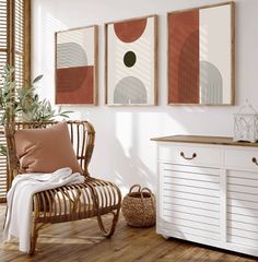 three framed art prints hang on the wall above a chair and sideboard in a white room