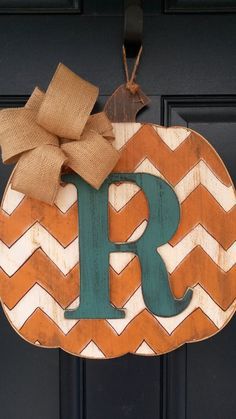 a wooden monogrammed sign with a bow hanging from it's front door