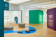 an art museum with various colored walls and sculptures on the floor, including two benches