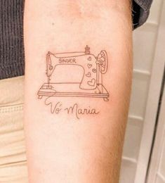 a woman with a tattoo on her arm that says, singer no sewing machine in front of an ironing board