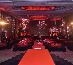 an empty banquet hall with red lighting and black tablecloths on the dance floor