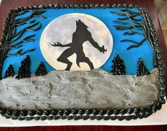 a cake decorated with the silhouette of a bigfoot in front of a full moon