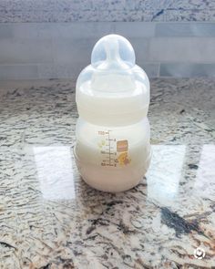 a baby bottle sitting on top of a marble counter