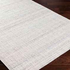 a white rug on top of a wooden floor