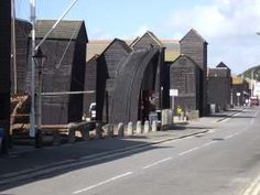 a row of wooden buildings sitting on the side of a road next to a street