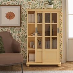 a room with a chair, bookshelf and wallpaper