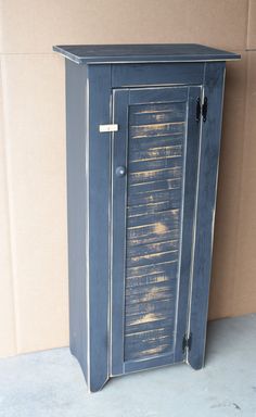 a blue cabinet sitting in front of a cardboard box