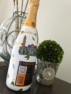 a bottle of champagne sitting on top of a table next to a potted plant