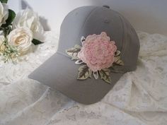 "I designed this adorable grey Youth Toddler baseball cap with a beautiful embroidered Pink Flower. This hat is so cute. These hats are really nice quality. Inside dimensions is approximately 20\" the velcro strap will add 3\" larger or smaller. velcro pony tail back These hats are washed cotton twill. see more youth toddler cadet and baseball hats here: https://www.etsy.com/shop/theraggedyrose?ref=seller-platform-mcnav&section_id=21134612 CUSTOM ORDERS ALWAYS WELCOME.... Will ship in 1 to 2 Gray Brimmed Baseball Cap, One Size Fits Most, Gray Cotton Baseball Cap For Spring, Spring Gray Cotton Baseball Cap, Gray Cap For Spring, Gray Spring Cap, Adjustable Brimmed Gray Baseball Cap, Gray Baseball Cap For Spring, Gray Snapback Hat For Spring, Gray Curved Brim Baseball Cap For Spring