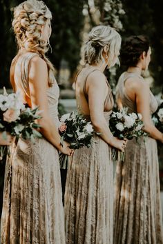 the bridesmaids are wearing gold dresses and holding bouquets in their hands as they look at each other