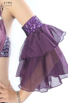 the woman is wearing a purple dress with sequins on it's waist