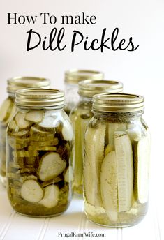 four jars filled with pickles sitting on top of a white table next to the words how to make dill pickles